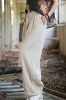 Woman wearing beige sandwashed ramie linen relaxed fit pants with hand in pocket.