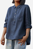 Vintage linen shirt in navy blue, casual loose fit with button front and chest pocket, styled with rolled-up sleeves and light-wash distressed jeans.