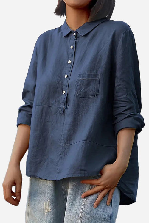 Vintage linen shirt in navy blue, casual loose fit with button front and chest pocket, styled with rolled-up sleeves and light-wash distressed jeans.