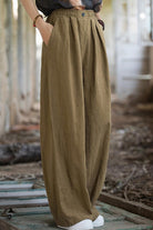 Relaxed fit sandwashed ramie linen pants with plush lining in olive green color worn with white sneakers.