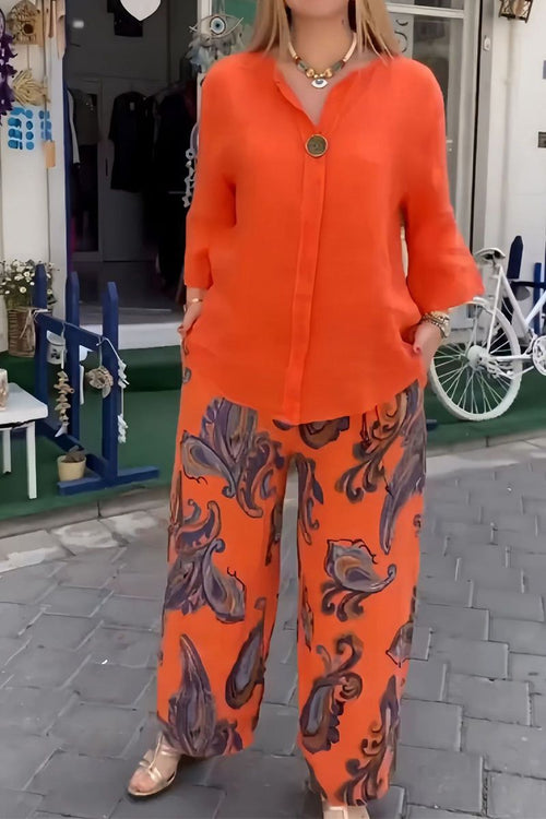 woman wearing vibrant fusion two-piece set with orange top and patterned wide-leg pants