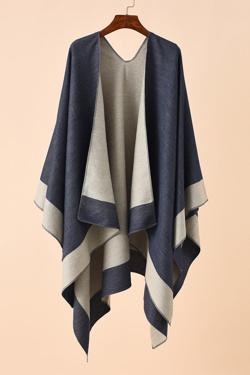 Two-tone elegant knitted poncho with flowing silhouette and sophisticated drape on hanger