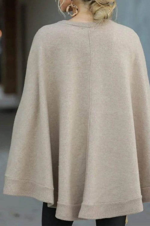 Back view of beige elegant poncho pullover made from soft, lightweight fabric with relaxed fit and ribbed edges