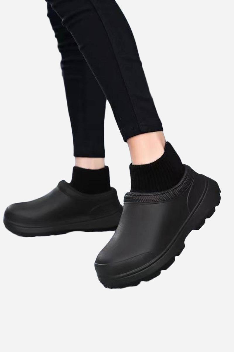 Black fleece-lined comfort clogs with waterproof exterior and sturdy sole worn with black leggings