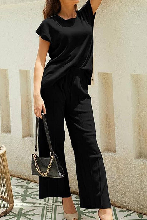 First Class Travel black two-piece set with pleated wide-leg pants and short sleeve top for versatile comfort and wrinkle resistance.