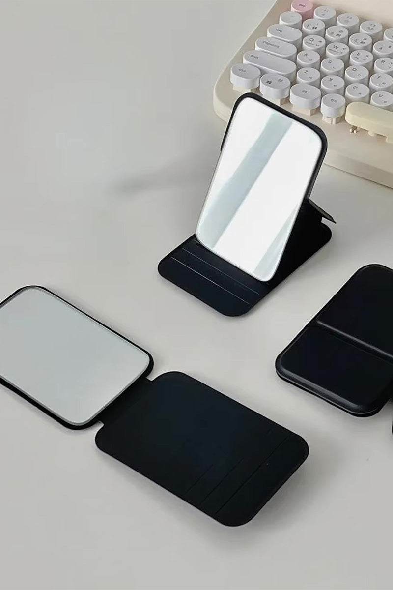 Compact travel pocket mirror with durable black PU leather case, clear glass reflection, lightweight and portable for on-the-go use.