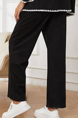 Black knit pants from a mix and match contrast-trim knit cardigan set worn with white sneakers