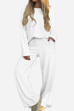 White relaxed fit two-piece set with wide-leg pants and button-cuff top designed for comfortable, wrinkle-resistant travel wear