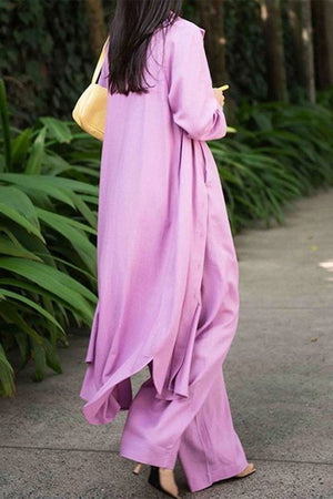 Woman wearing a soft pink relaxed fit shirt and trouser three-piece set walking outdoors