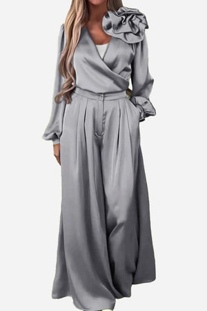 Elegant gray satin two-piece set with statement shoulder blouse and flowing palazzo pants