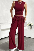 Woman wearing burgundy Stroll & Hangout Ribbed Knit sleeveless top and wide-leg pants two-piece set with casual white sneakers.