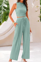 Woman wearing a Stroll & Hangout Ribbed Knit two-piece set with sleeveless crop top and wide-leg pants in light green.