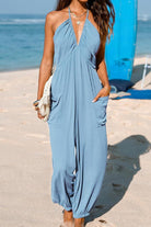 Blue Sunshine On Sand halter-neck jumpsuit with ruched neckline and elastic ankle cuffs on a beach setting