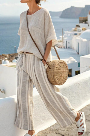 Woman wearing Coastal Comfort Linen two-piece set with striped wide-leg pants and loose top by the seaside.