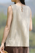 Woman wearing sleeveless Dandelion Fields Cotton Linen top in beige back view against blurred outdoor background