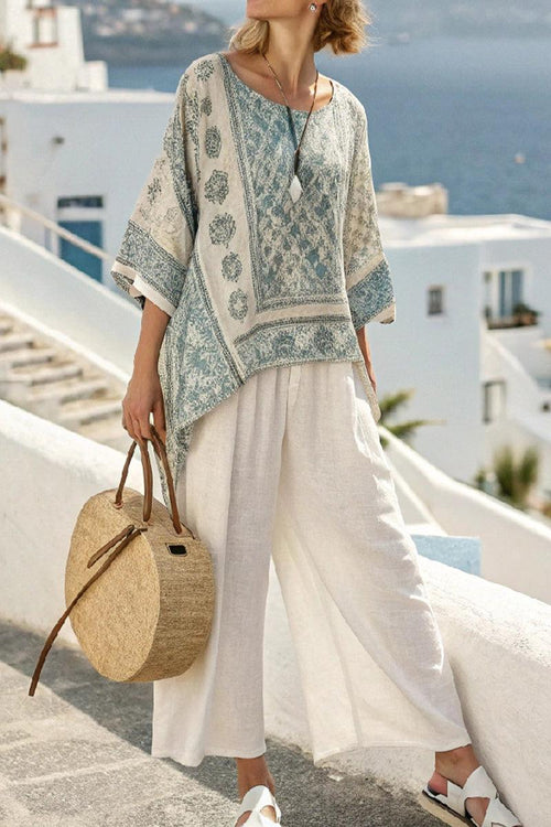 Santorini Sunset Striped two-piece set with flowing top and wide-leg pants in soft fabric, styled with round bag by the sea