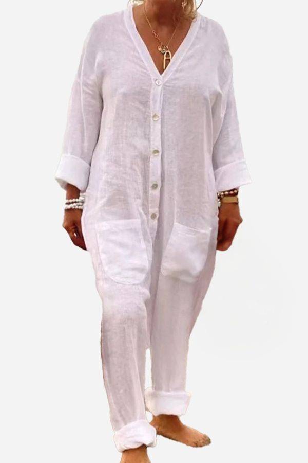 White relaxed jumpsuit with button-front, deep V neckline, and rolled sleeves for casual summer wear.