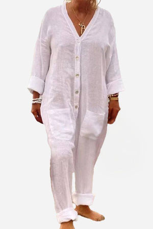 White relaxed jumpsuit with button-front, deep V neckline, and rolled sleeves for casual summer wear.