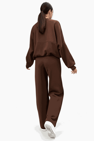 Woman wearing The Voyager Zip Set brown zip-front sweatshirt and wide-leg joggers back view