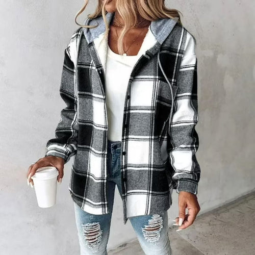 Woman wearing a Highland Plaid Shacket with black, white, and gray plaid, hood, button front, and soft fleece lining, paired with ripped jeans and holding a coffee cup.