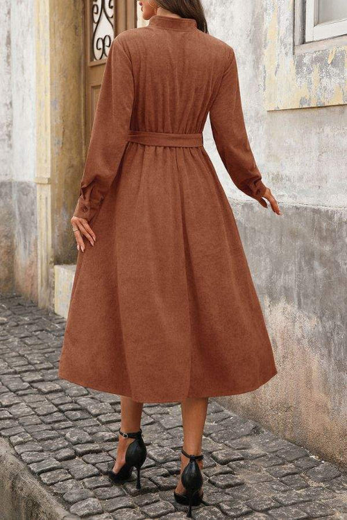 Back view of effortlessly polished corduroy tie-waist dress in rich brown mid-calf length with long sleeves and button cuffs.