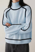 Light blue Zero Itch Turtleneck Sweater with black contrast trim, soft knit, relaxed modern fit, and slimming silhouette