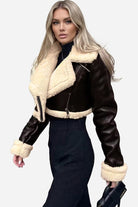Cropped faux leather sherpa jacket with cream fleece lining and trim, styled on a model.