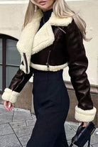 Cropped faux leather jacket with cream sherpa lining and trim, featuring a zipper front and fitted waist.