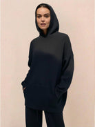 woman wearing black waffle-knit two-piece hoodie and pants lounge set