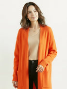 Long Australian Merino Wool cardigan with open front, ribbed cuffs, and front pockets.