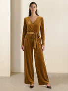 Woman wearing deep V-neck velvet suit with long sleeves and wide-leg pants