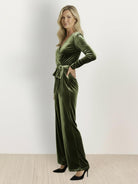 Deep V-neck velvet suit with long sleeves, removable waist tie, and wide-leg pants designed for formal events.