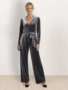 Woman wearing deep V-neck velvet suit with wide-leg pants and removable waist tie