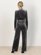 Deep V-neck velvet suit with long sleeves, removable waist tie, and wide-leg pants in structured, flexible fabric
