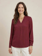 White pleated V-neck long-sleeve blouse with button cuffs and relaxed fit