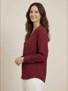 Pleated V-neck long-sleeve blouse with diagonal pleated panel and button cuffs