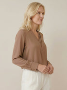 White pleated V-neck long-sleeve blouse with button cuffs and relaxed fit