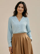 White pleated V-neck long-sleeve blouse with button cuffs and relaxed fit