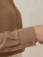 Women’s pleated V-neck long-sleeve blouse with button cuffs and relaxed fit