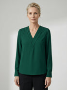 White pleated V-neck long-sleeve blouse with diagonal panel and button cuffs