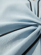 Woman wearing a knot-waist maxi dress with V-neckline and flowing skirt