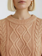 Oversized cable-knit crewneck sweater with dropped shoulders and ribbed cuffs