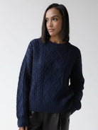 Oversized cable-knit crewneck sweater with dropped shoulders and ribbed trim