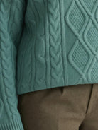 Oversized cable-knit crewneck sweater with dropped shoulders and thick plush fabric