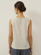 White cotton-linen sleeveless top with round neckline and button back closure