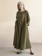 100% cotton-linen empire waist dress with round neckline, 3/4 sleeves, natural crinkle texture, and deep side pockets