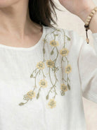 Cotton-linen embroidered blouse with relaxed boxy fit, 3/4 balloon sleeves, elastic cuffs, and tonal floral embroidery on shoulder.