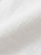 White Tencel-linen blend pleated wide-leg pants with structured waist and floor-length silhouette