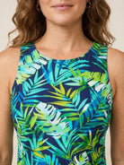 Woman wearing high-neck ruched tankini set with side ruching and built-in brief at the beach