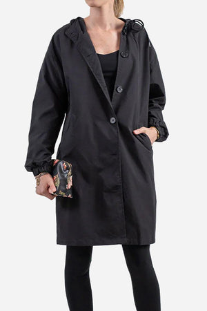 Black oversized water-resistant windbreaker with hood and buttons, worn by model